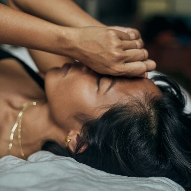 Client receiving gentle, grounded massage therapy for nervous system regulation