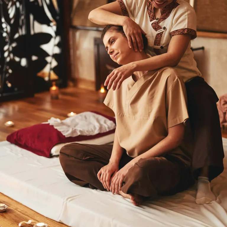 Client receiving assisted stretching during traditional Thai bodywork session
